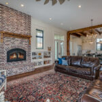 a room with a fireplace, chairs and a couch. on the floor is an ornate area rug